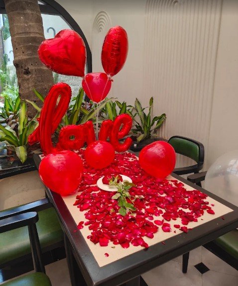 Romantic rose petal table with love balloons and heart balloons